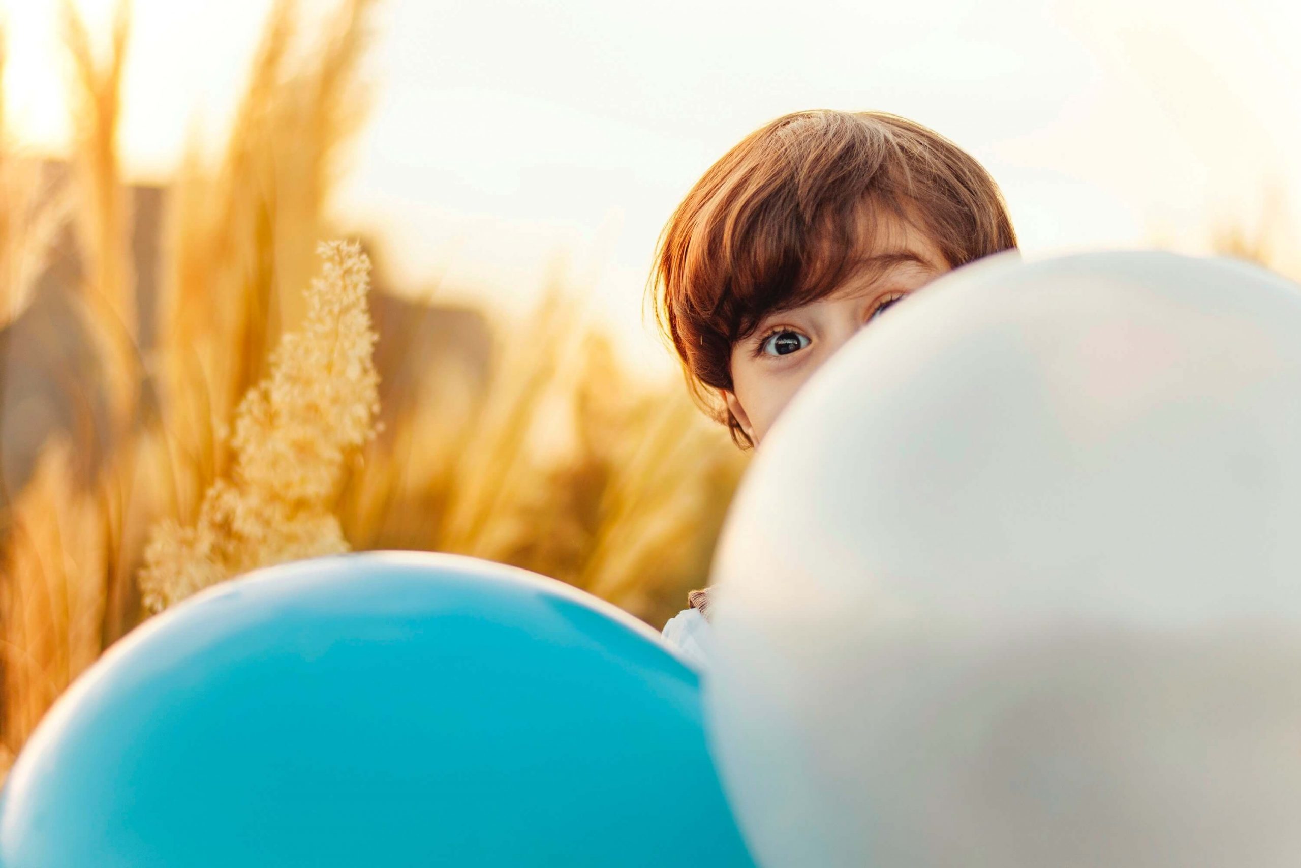 Photo d'un enfant caché derrière des ballons